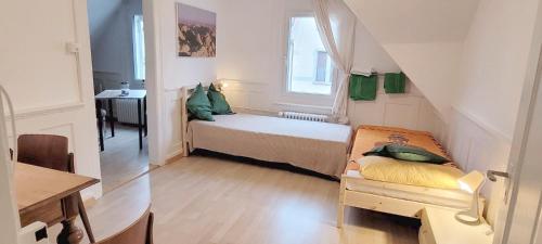 um pequeno quarto com uma cama e uma janela em 3 Zi Wohnung Stilvoll im Gertrud Schlössli - zentral ruhig em St. Gallen