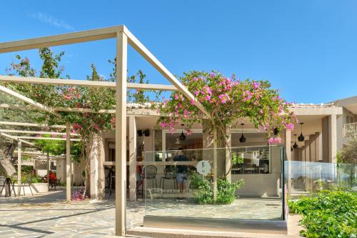 a glass building with pink flowers in the courtyard at White Olive Premium Lindos in Pefki Rhodes