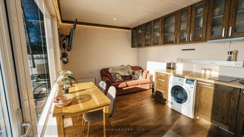 a kitchen and living room with a washing machine at Juusa cabin in Otepää