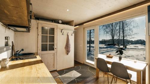 Juusa cabin في أوتيبا: مطبخ مع طاولة وكراسي ونافذة