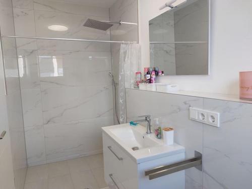 a white bathroom with a sink and a shower at ganze Ferienwohnung 73m² in Wittlich in Wittlich