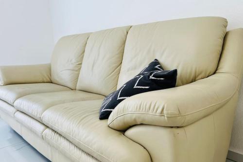 a white couch with two black pillows on it at Neue Wohnung für 4 Küche Terrasse in Wittlich