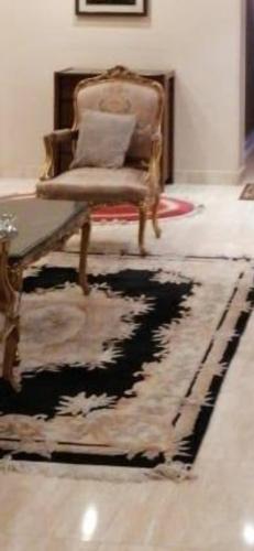 uma sala de estar com uma cadeira e um tapete em شقق فندقية العريش 