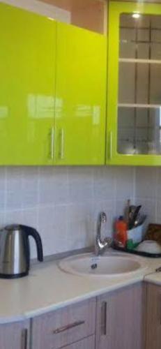 una cocina con armarios de color verde lima y fregadero en شقق فندقية العريش, 
