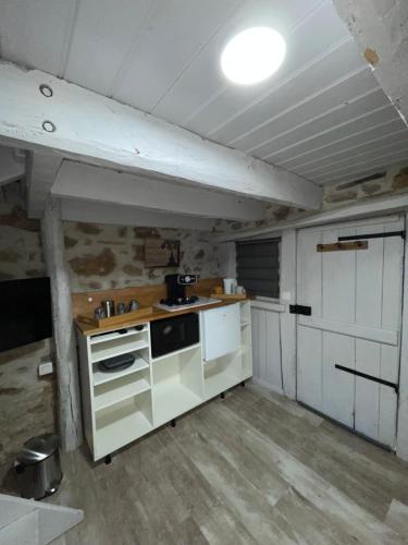 a kitchen with a stove and a sink in a room at Séjour à la Marronnie in Saint-Germain-les-Vergnes