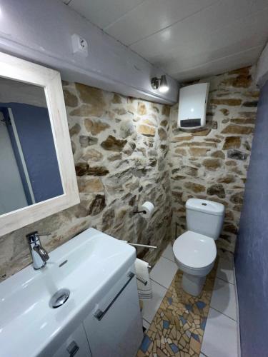 a bathroom with a white toilet and a sink at Séjour à la Marronnie in Saint-Germain-les-Vergnes