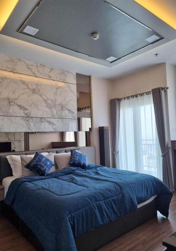 a bedroom with a large blue bed with a stone wall at Luxury 31st Top Floor Condo with Swimming Pool in Chiang Mai