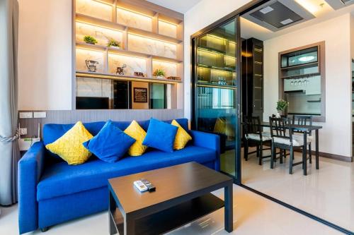a living room with a blue couch and a table at Luxury 31st Top Floor Condo with Swimming Pool in Chiang Mai