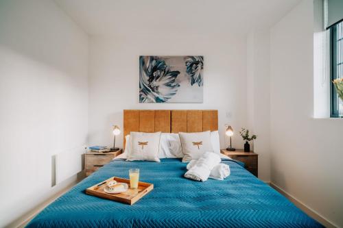 a bedroom with a blue bed with a tray on it at Canal view, Grade II Industrial style, Fast WiFi, Family, Contractors in Birmingham
