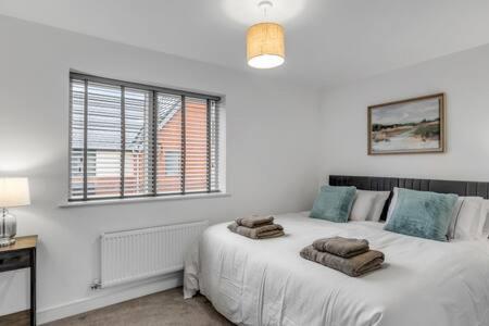 a bedroom with a bed with towels on it at 2 bedroom house NE Norwich in Norwich