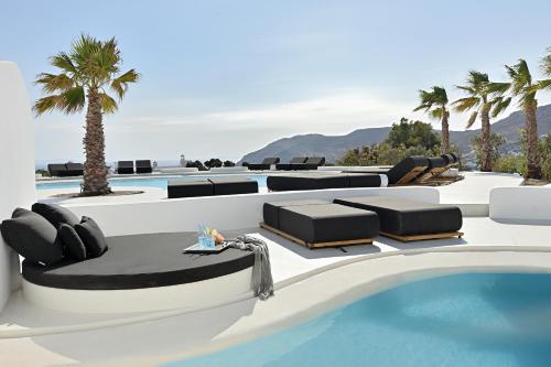 un complexe avec une piscine et des palmiers dans l'établissement Million Stars Mykonos, à Mykonos