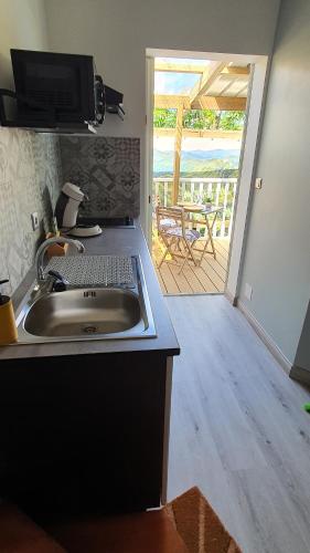 a kitchen with a sink and a view of a patio at Les Clairs Matins in Saint-Benoît