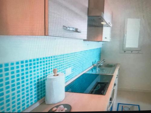 cocina con azulejos azules en la pared y fregadero en Castelsardo, en Castelsardo