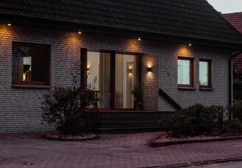 une maison en briques avec des lumières à l'avant dans l'établissement Bungalow Appartements - "Studio Living", à Haselünne