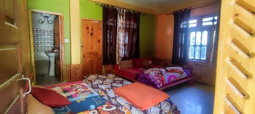 a bedroom with two beds in a room with a window at Little Hamlet Choj in Kasol
