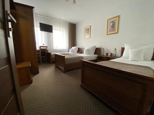 um quarto de hotel com duas camas e um sofá em Hotel Constancja em Czestochowa