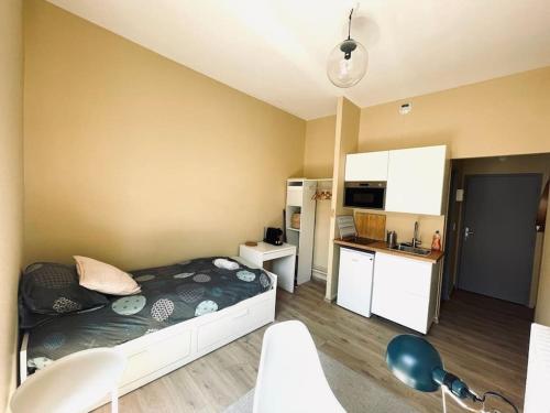 une petite chambre avec un lit et une cuisine dans l'établissement Studio boucle 7, à Besançon