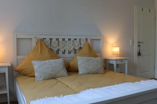 a white bed with two pillows and two tables at Gemütliches Traumhaus im Grünen in Swisttal