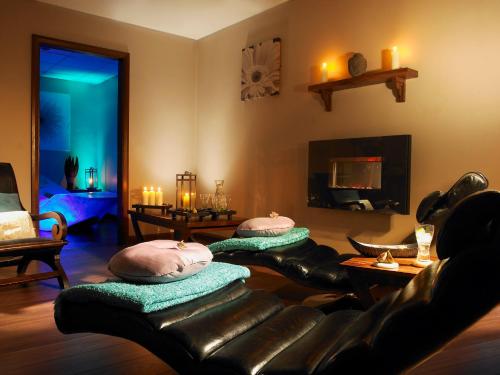 a living room with two leather couches and candles at Bridge House Hotel, Leisure Club & Spa in Tullamore