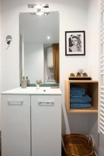 une salle de bain blanche avec un lavabo et un miroir dans l'établissement Studio cosy avec parking, à Lyon