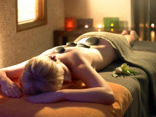 a woman laying on a bed in a towel at Bridge House Hotel, Leisure Club & Spa in Tullamore