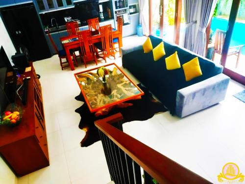 uma sala de estar com um sofá azul e uma mesa em 3Bedroom Villa Kepiting Sanur em Sanur