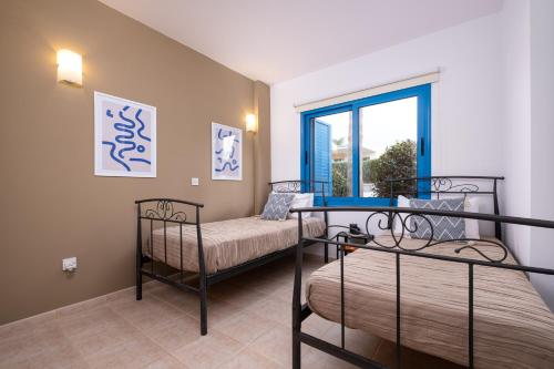 a bedroom with two bunk beds and a window at Kyma II Beachfront Residence in Polis Chrysochous