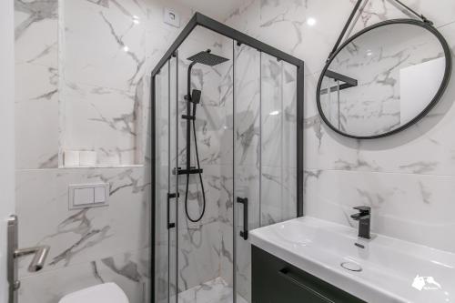 uma casa de banho com um chuveiro, um lavatório e um espelho. em MBA - Splendide Appart - Patay 2 - Proche Bercy em Paris