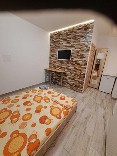 a bedroom with a bed and a brick wall at Memorandului Residence in Timişoara