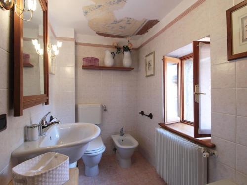 a bathroom with a sink and a toilet and a mirror at Retreat in the Dolomites in Chies dʼAlpago