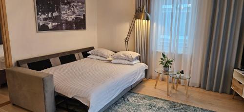 ein kleines Schlafzimmer mit einem Bett und einem Tisch in der Unterkunft Jakobsoni 7 Apartment in Tallinn