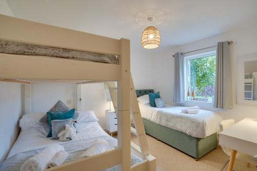 una camera con due letti a castello e una finestra di Eider Cottage: Lake View & Access in the Cotswolds a Cirencester
