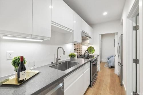 a white kitchen with a sink and a bottle of wine at Charming apt in Pacific Heights in San Francisco
