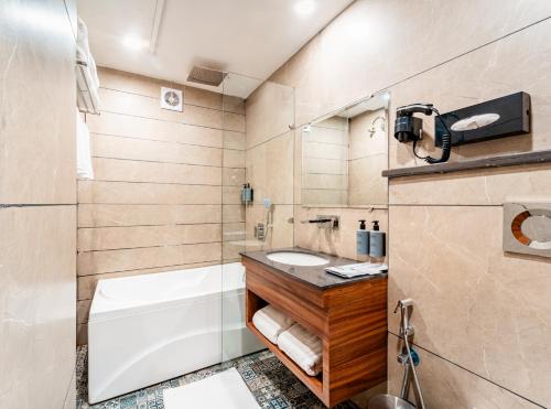 a bathroom with a tub and a toilet and a sink at Playotel Inn, Chandigarh in Zirakpur