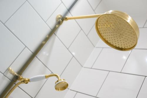 a shower with a straining shower head on a wall at Queen Charlotte Guesthouse in Edinburgh