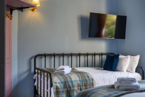 a bedroom with two beds and a tv on the wall at Queen Charlotte Guesthouse in Edinburgh
