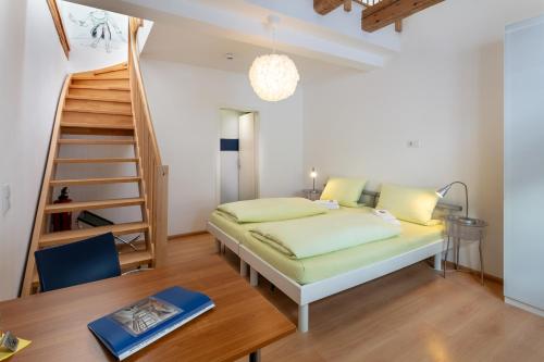 1 dormitorio con 1 cama y escalera de caracol en Pensionsieben Das andere Hotel, en Lörrach