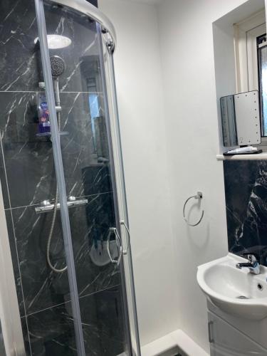 a bathroom with a shower and a sink at Jmk home in Lexden