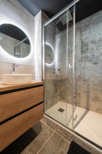 une salle de bain avec une douche en verre et un lavabo dans l'établissement Le Modania - Modane Gare - A 15 mn des pistes, à Modane