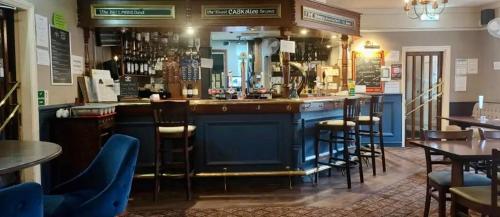 a bar in a restaurant with tables and chairs at The Bell Hotel in Burgh le Marsh