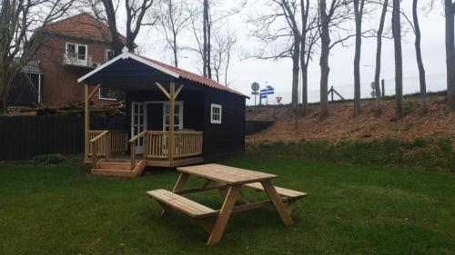 una mesa de picnic y un pequeño cobertizo en un patio en Camping de Noorde, en Zwartsluis