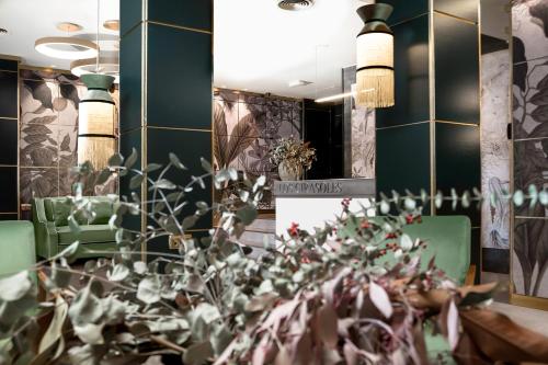 une salle à manger avec des chaises vertes et une table avec une plante dans l'établissement Hotel Los Girasoles, à Grenade