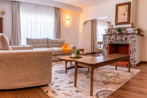 a living room with a couch and a fireplace at Silverbeck Residence, Nanyuki in Nanyuki