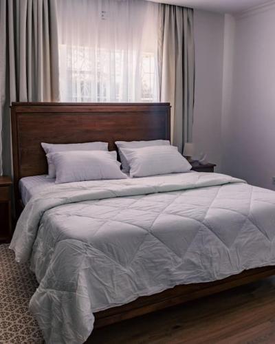 a large bed with a wooden headboard in a bedroom at Silverbeck Residence, Nanyuki in Nanyuki