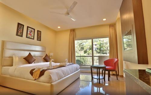 a bedroom with a bed and a table and a window at MJ Hills Rishikesh in Rishīkesh