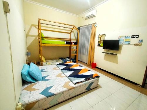 1 Schlafzimmer mit 2 Etagenbetten und einem TV in der Unterkunft Green Surabaya Homey in Surabaya