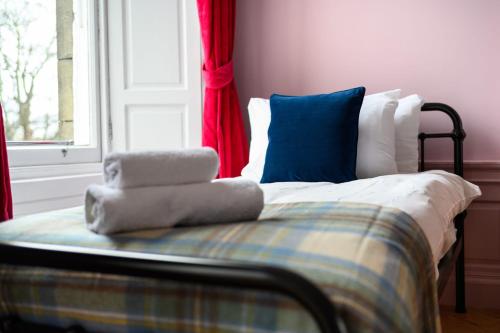 a bed with pillows on it in a room with a window at Queen Charlotte Guesthouse in Edinburgh