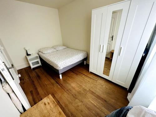 a small bedroom with a bed and a mirror at Appartement 2 pièces in Malakoff