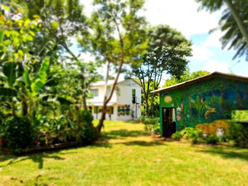 um quintal com um edifício azul e árvores em EcoPousada - Sitio Aborigene em São Lourenço do Oeste