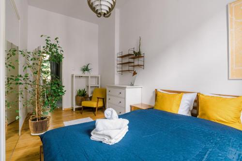 ein Schlafzimmer mit einem blauen Bett und einem Handtuch darauf in der Unterkunft Plac Grunwaldzki Cosy Apartment in Breslau